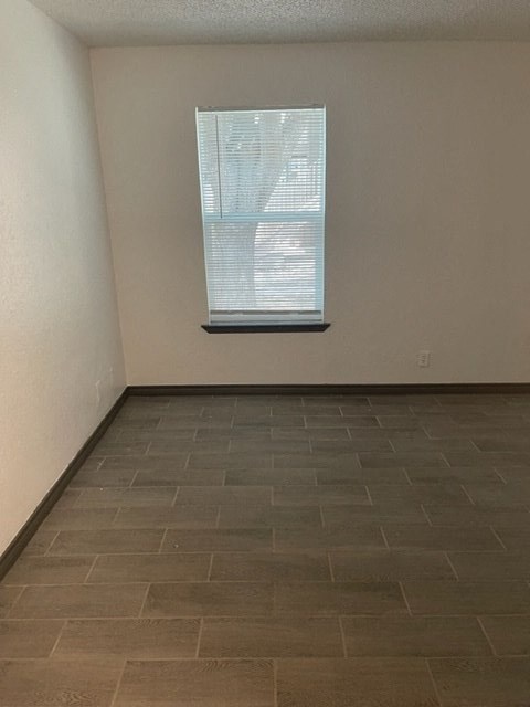 an empty room with a window and a tiled floor