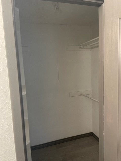 a white closet with shelves and a door