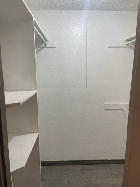 a white bathroom with shelves and a closet