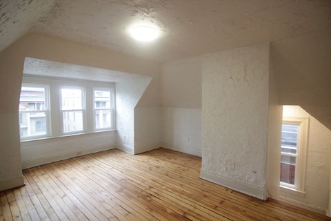 an empty living room with wood floors and white walls