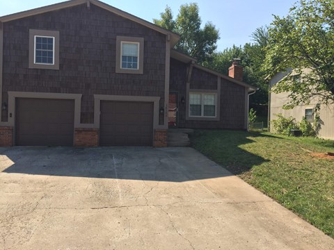 A house with a brown facade and two garages.