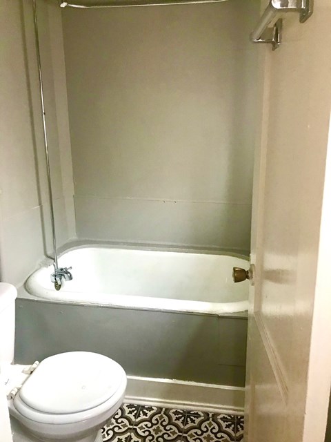 A white toilet sits next to a bathtub in a bathroom.