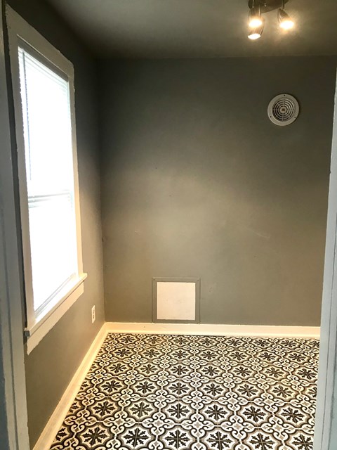 A room with a patterned floor and a window.