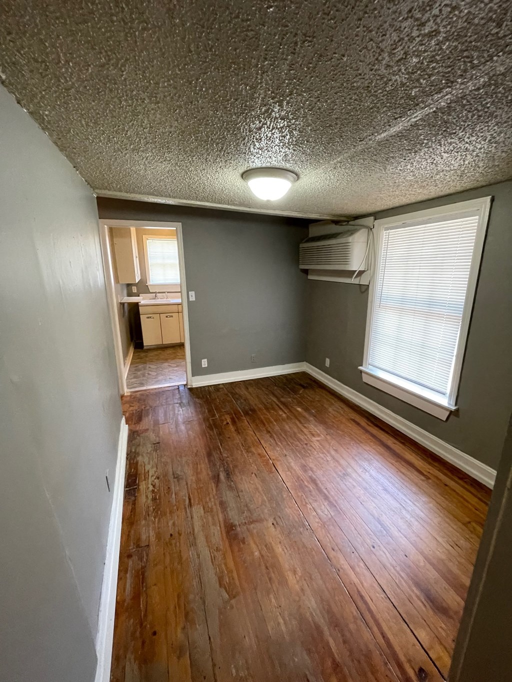an empty room with a hard wood floor and a window