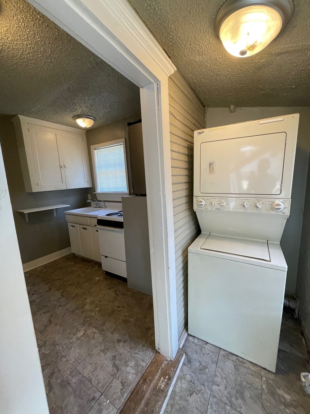 an empty kitchen with a washer and dryer in it