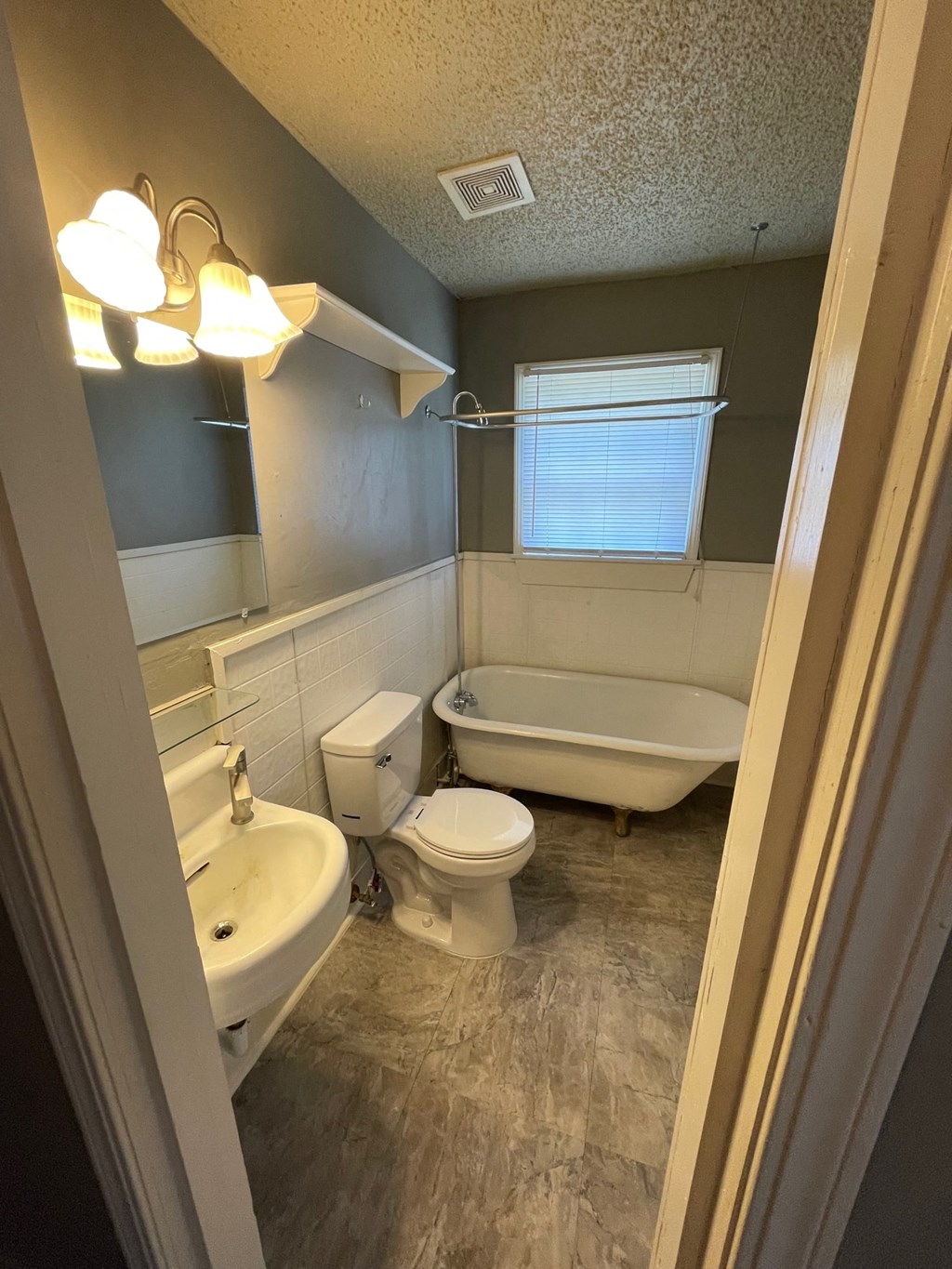 a bathroom with a toilet and a tub and a sink