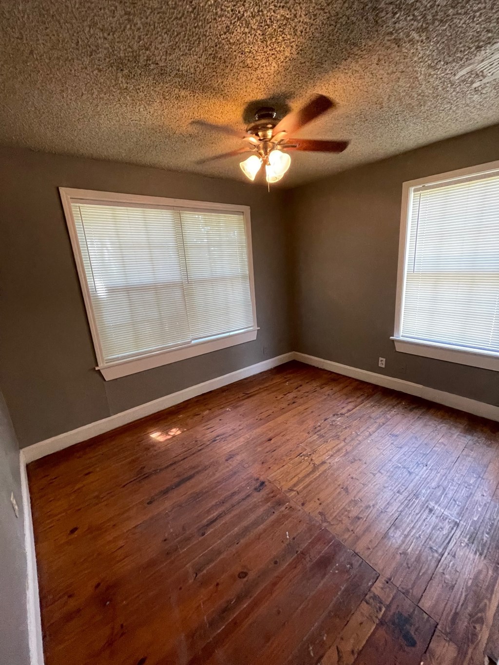 a living room with wood floors and a ceiling fan