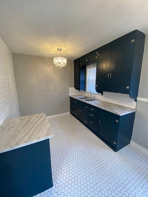 a kitchen with black cabinets and a counter top and a sink