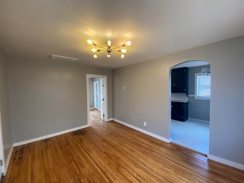 a empty living room with wood floors and a ceiling fan