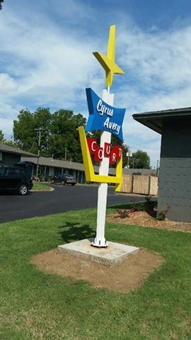 A signpost with a yellow star and a sign that says "Cwrw Abergavenny".