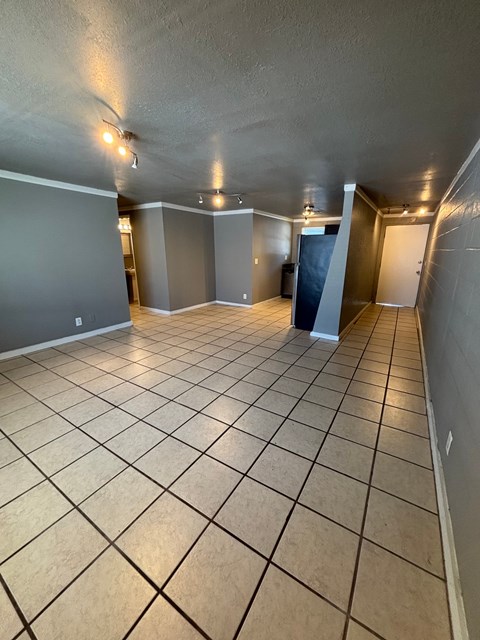 A spacious room with tiled flooring and walls painted in a light grey color.