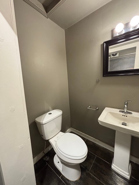 A white toilet sits next to a sink in a small bathroom.