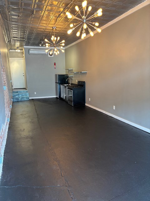 A room with a black floor and a ceiling with lights.