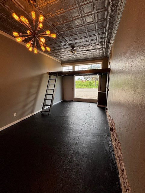 A room with a black floor and a ceiling with a light fixture.