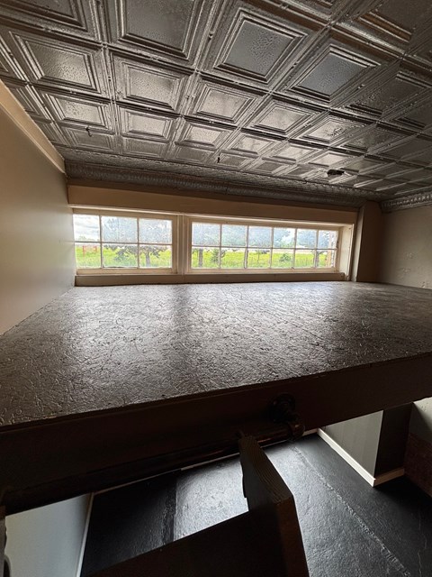 A room with a large table and a window overlooking a field.