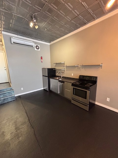 A kitchen area with stainless steel appliances and a staircase.