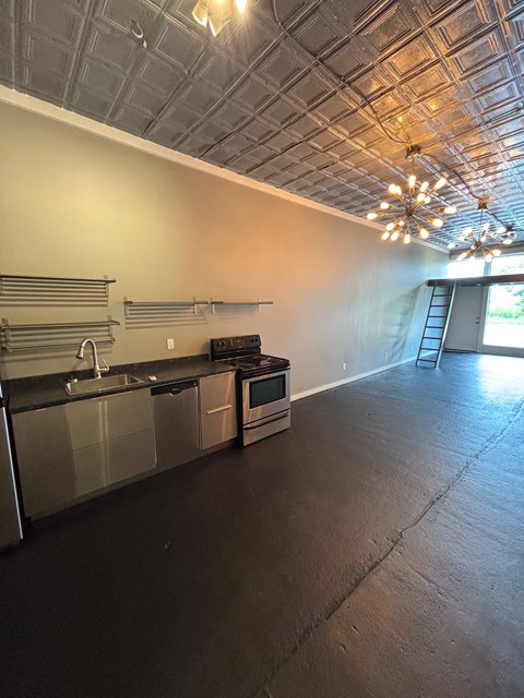 A kitchen with stainless steel appliances and a wooden floor.