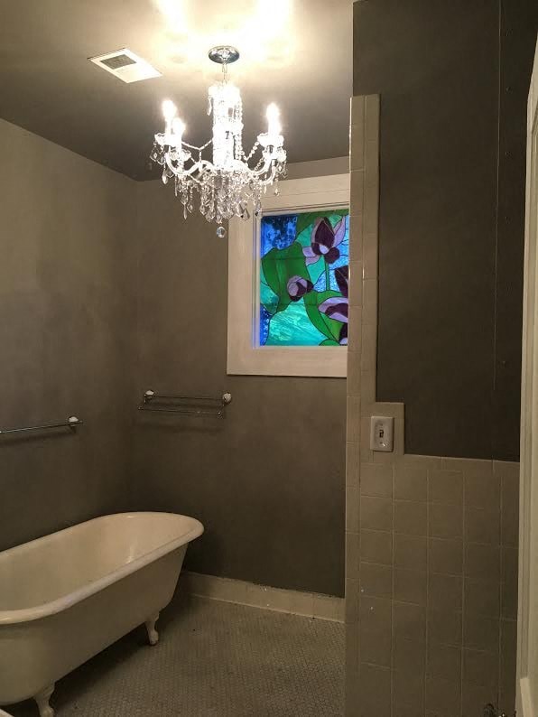 a bathroom with a white bath tub and a chandelier