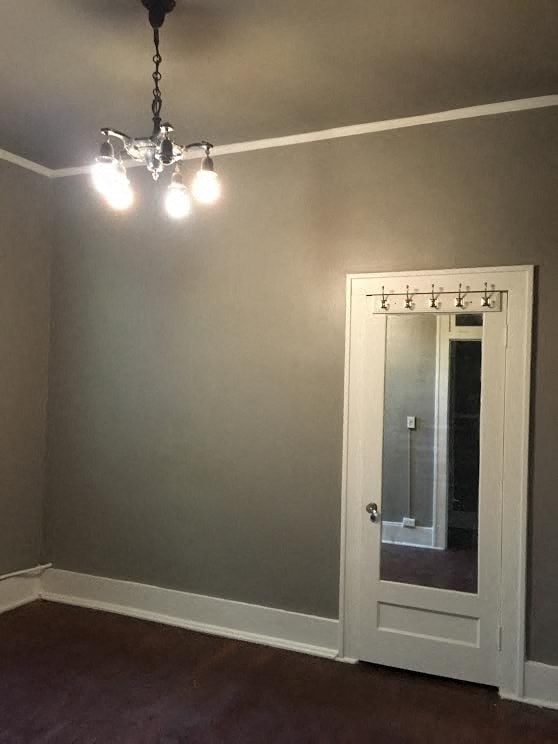 a living room with a white door and a chandelier
