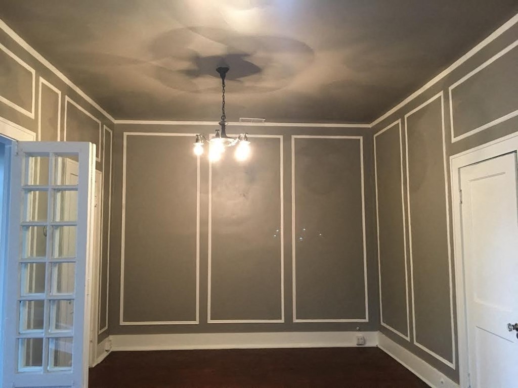 a dining room with gray walls and a ceiling with a chandelier