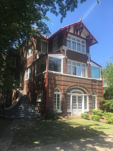 A red brick house with a white door and windows.