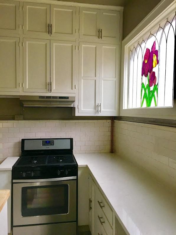 a kitchen with a stove and a stained glass window