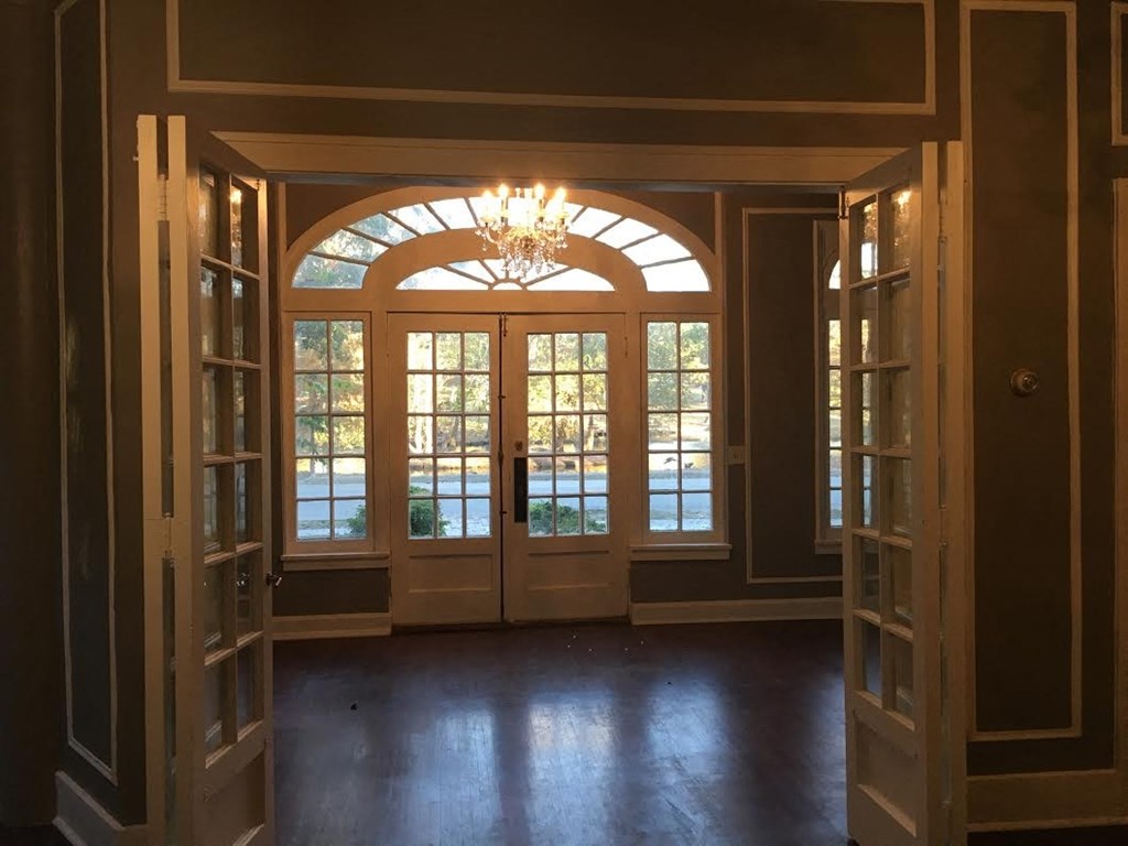 an empty room with a large window and a chandelier