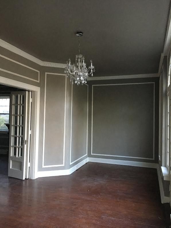 a living room with gray walls and a chandelier