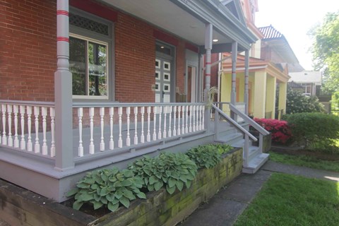 A red brick house with a white porch.