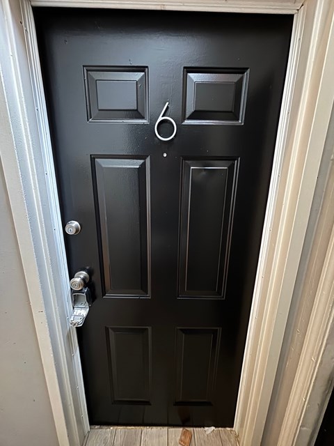 A black door with a silver handle and a doorknob.