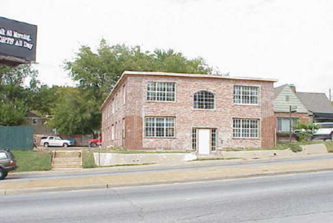 A red brick building with a white door and windows.