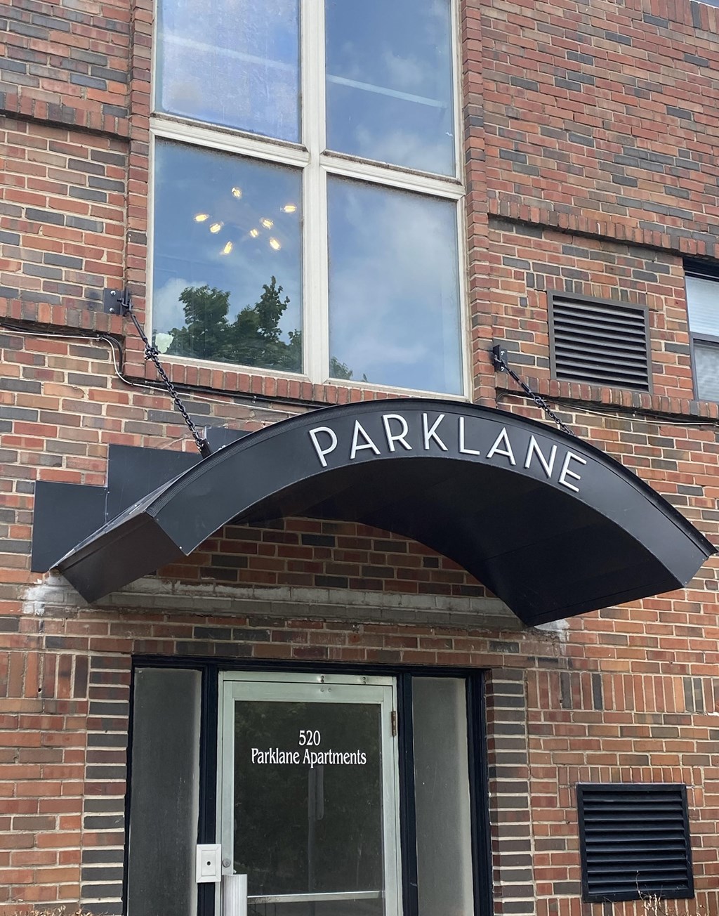 the front of a brick building with a black sign