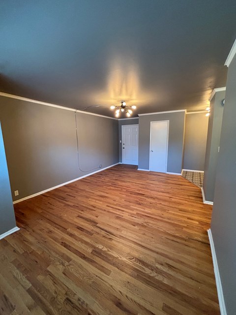 A room with wooden flooring and a chandelier.