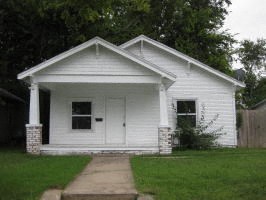 A small white house with a porch and a front door.