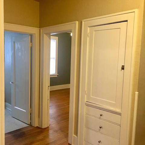 a bedroom with three doors and a dresser and a closet