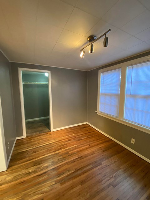 an empty room with a hard wood floor and a ceiling fan
