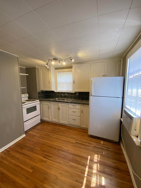 a kitchen with white cabinets and a refrigerator