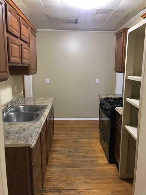 a kitchen with wooden floors and a sink and a stove