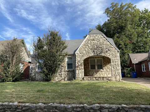 A stone building with a gable roof and a window.