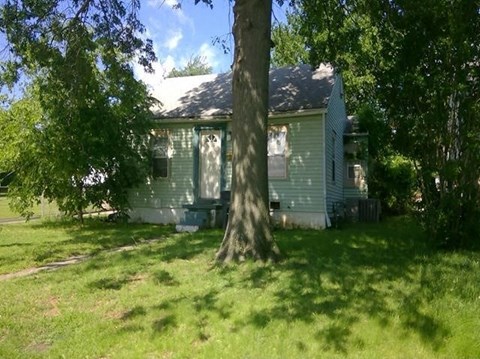 A house with a tree in front of it.