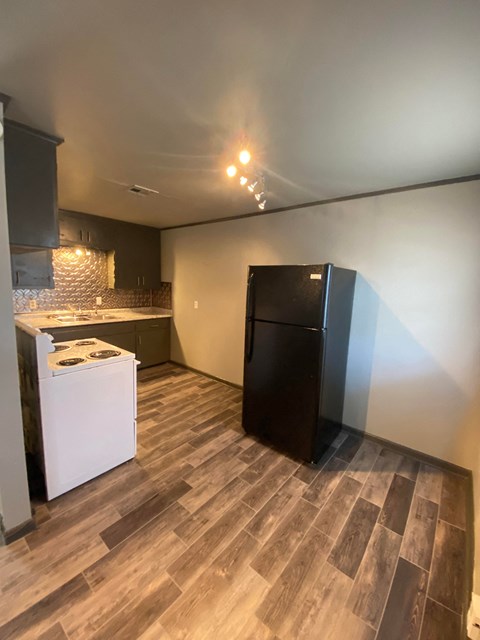 a kitchen with a refrigerator and a stove in a room