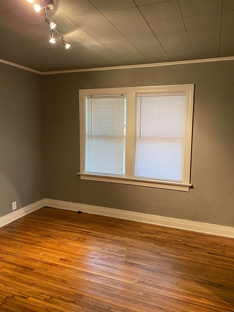an empty room with wood floors and a window