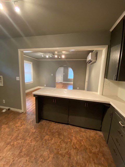 a kitchen with a counter top and a living room in the background
