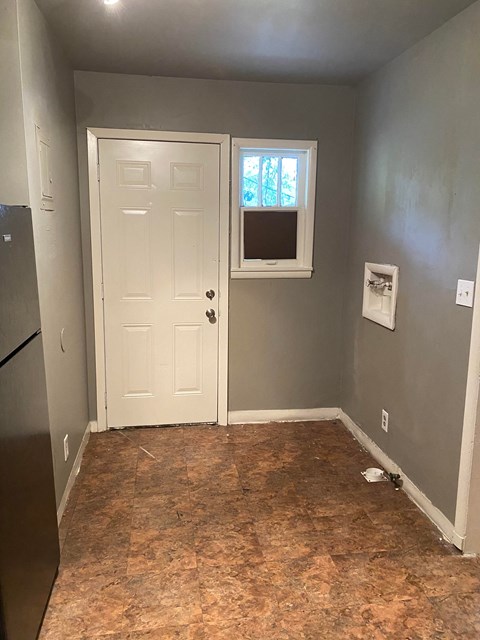 an empty room with a white door and a window