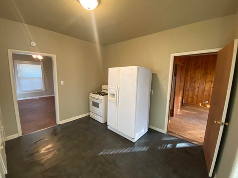a small kitchen with a refrigerator and a stove and a door