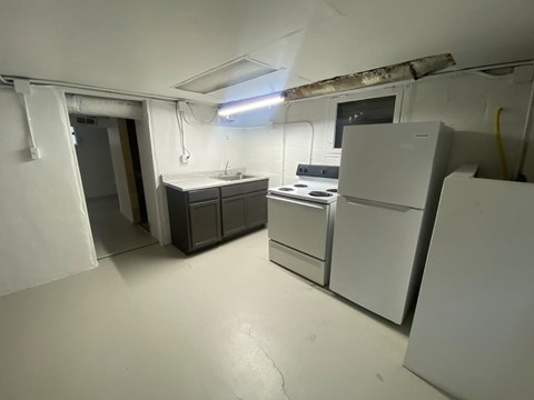 A kitchen with white appliances and a white floor.