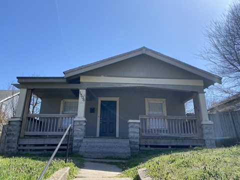 A house with a grey front porch and a black door.