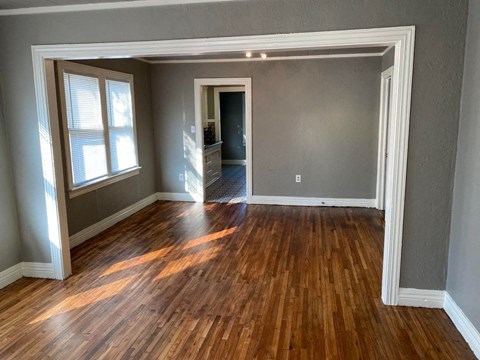 an empty living room with a hard wood floor