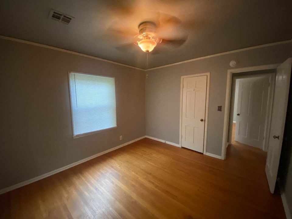 a living room with a wood floor and a ceiling fan