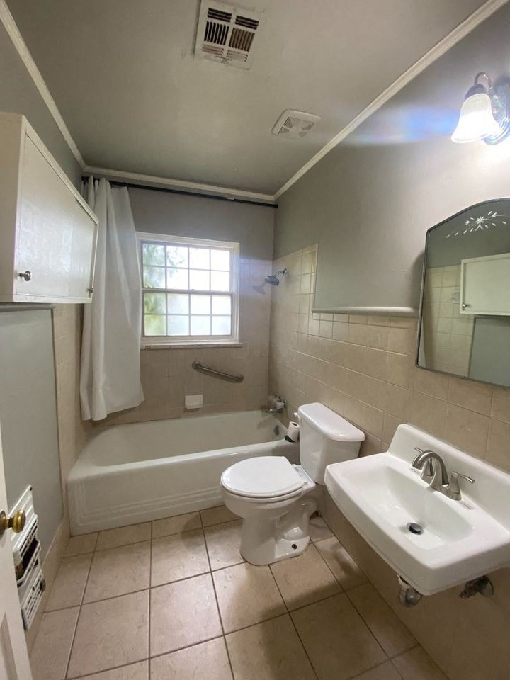 a bathroom with a toilet and a sink and a bath tub